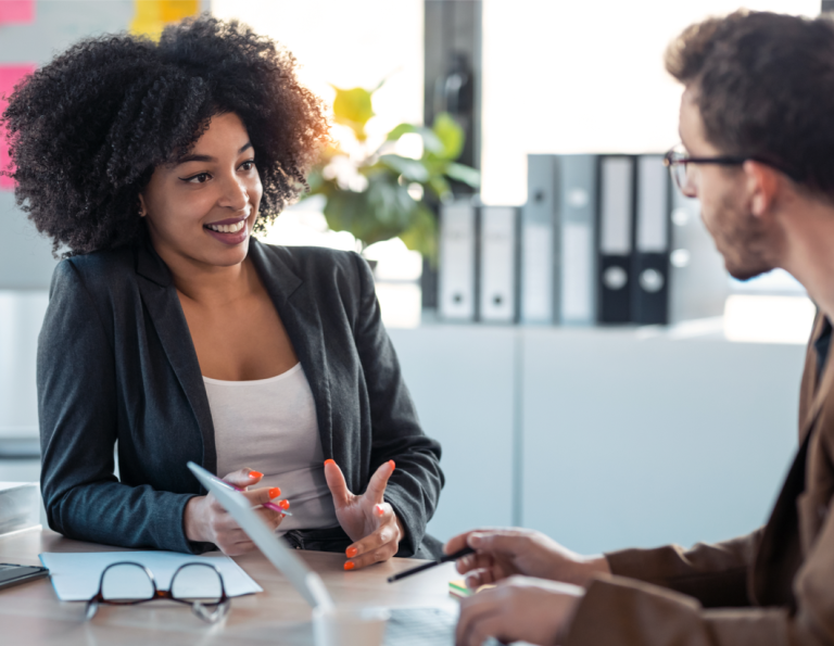 Male & female co-workers in friendly discussion in the office abut good mental health